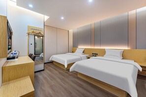 Une chambre d’hôtel moderne avec deux lits, un bureau en bois, un miroir et une armoire.