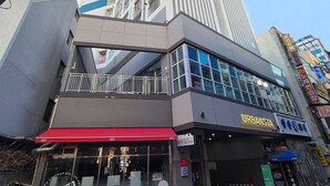A modern building with a restaurant named "URBANISTA" on the ground floor, featuring a red awning and outdoor seating. - W Stay Hotel Busan City Hall (Busan)