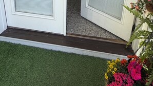 En dør med enkrans, et glasfelt og en lille plante.