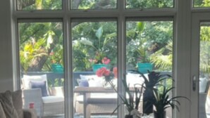 Ein Wohnzimmer mit großem Fenster, einer Couch und einem Couchtisch mit Dekoration.