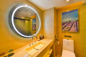 Een badkamer met een grote spiegel, een wastafel en een toilet.