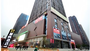 Un hotel alto con varios pisos y una entrada destacada.