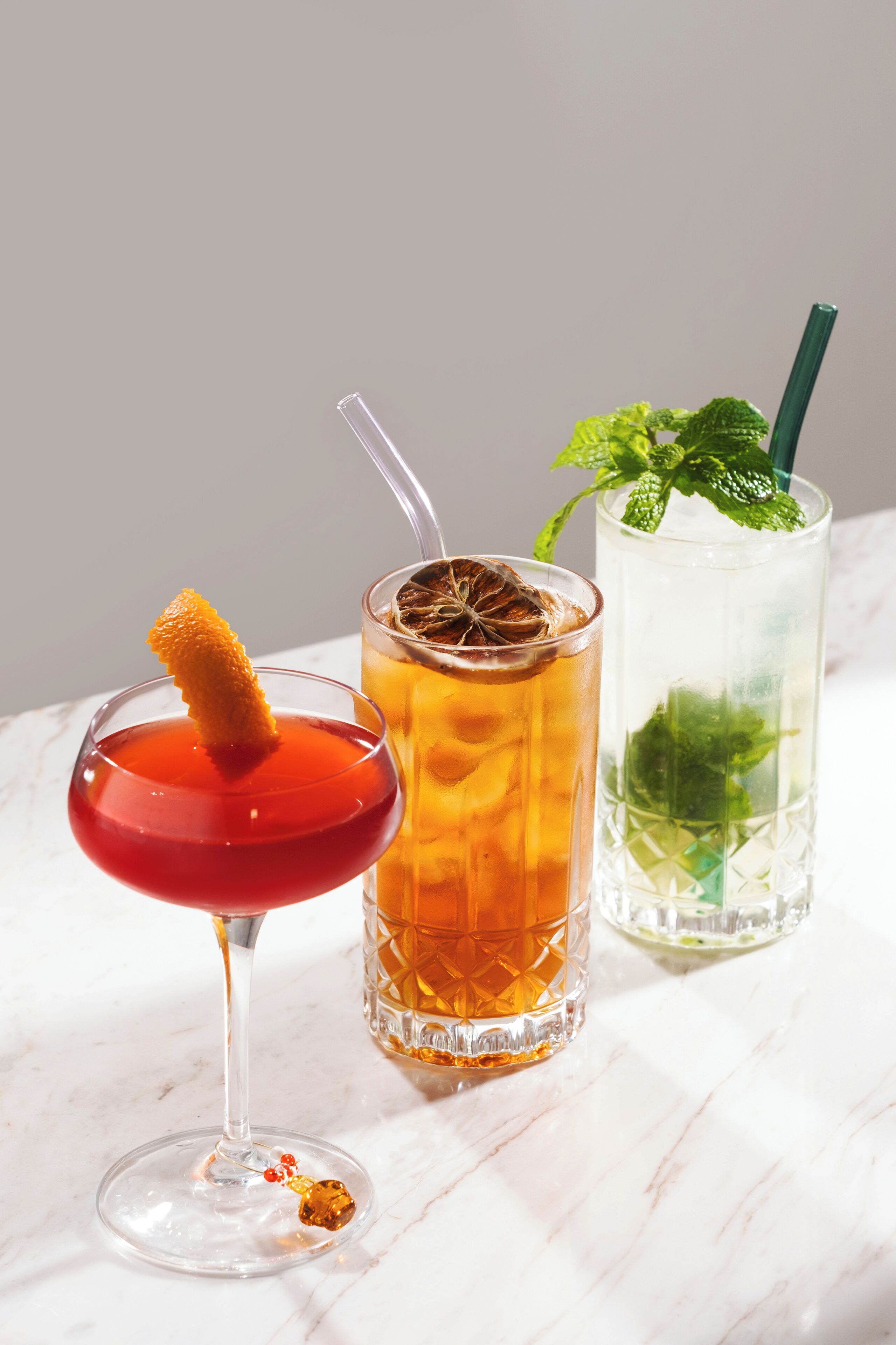 Three different drinks on a marble surface.