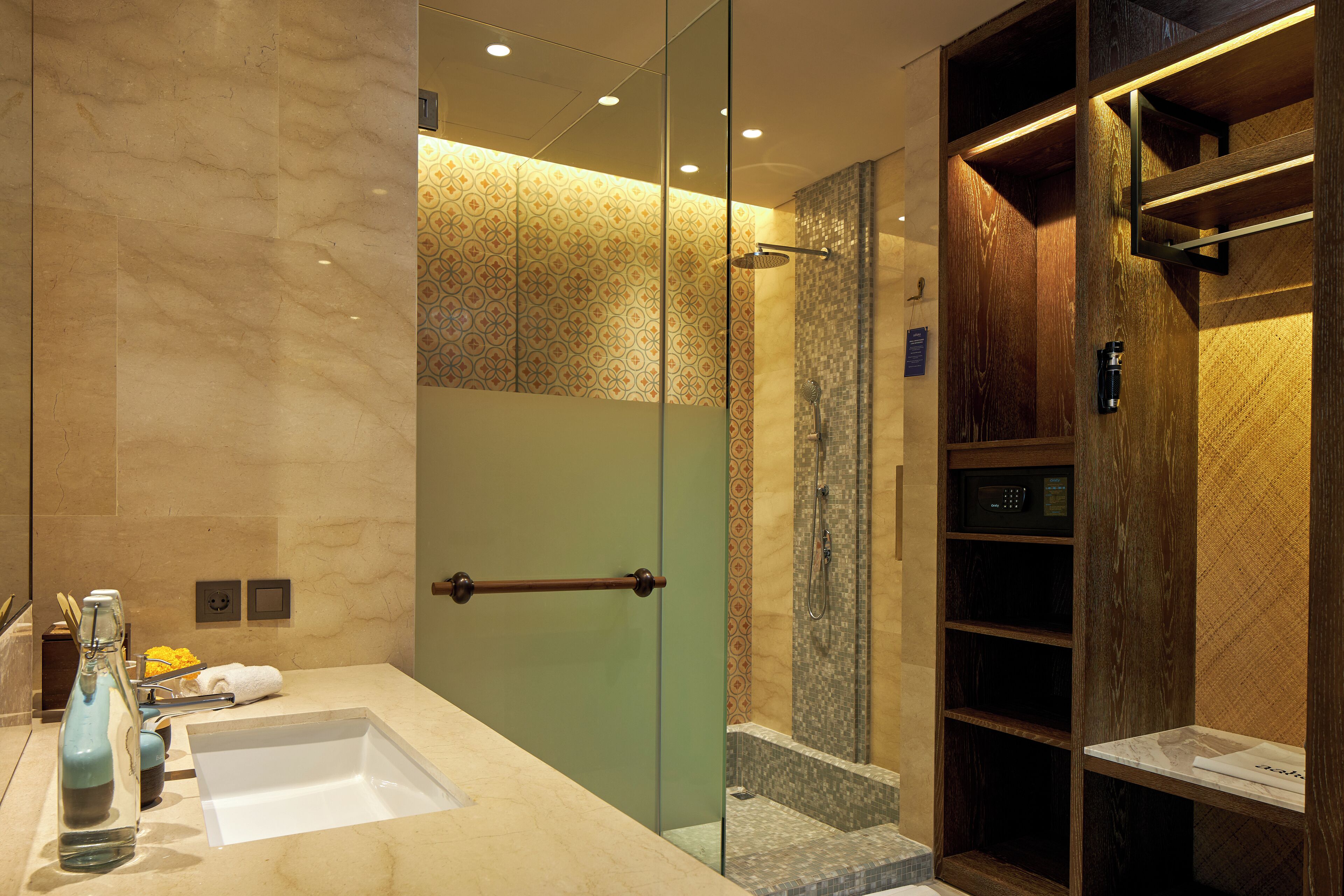 A modern bathroom with a glass shower enclosure, a vanity with a sink, and a built-in storage unit.