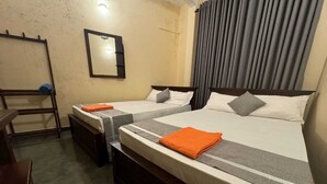 Une chambre d’hôtel avec deux lits, un miroir, un rideau et un banc en bois.