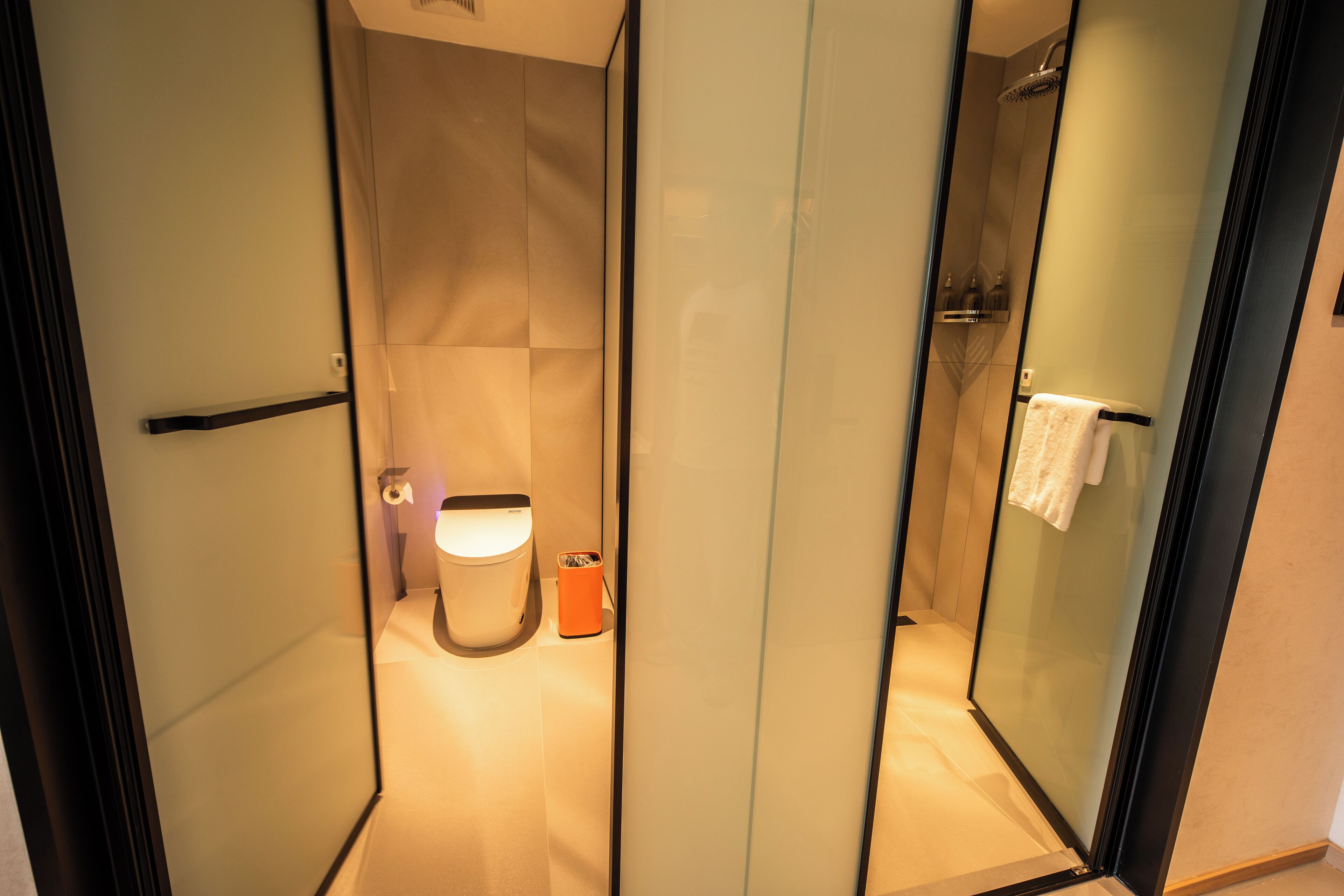 Een moderne badkamer met toilet, douche en hygiëneslot.