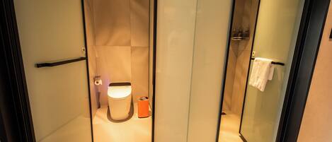 A modern bathroom with a toilet, bidet, and shower.