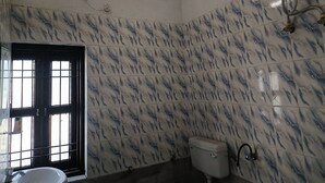 A bathroom with a toilet, sink, and window with bars.