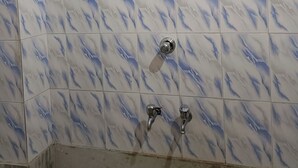 A bathroom with a tiled wall featuring a marble-like pattern.