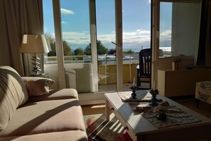 Olohuoneessa on sohva, sohvapöytä ja liukuovesta avautuu näkymä ulkotilalle.