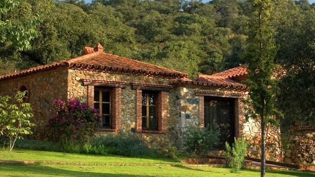 A stone house with a tiled roof, surrounded by lush greenery and trees. - La Tortuga, Stone House in Alájar (Alájar)