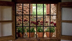 A window with a stone wall and potted plants. - La Tortuga, Stone House in Alájar (Alájar)