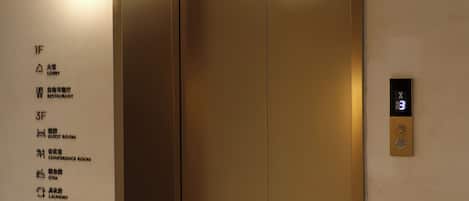Een moderne lift met verlichte vloerindicatoren en een digitaal displaypaneel.