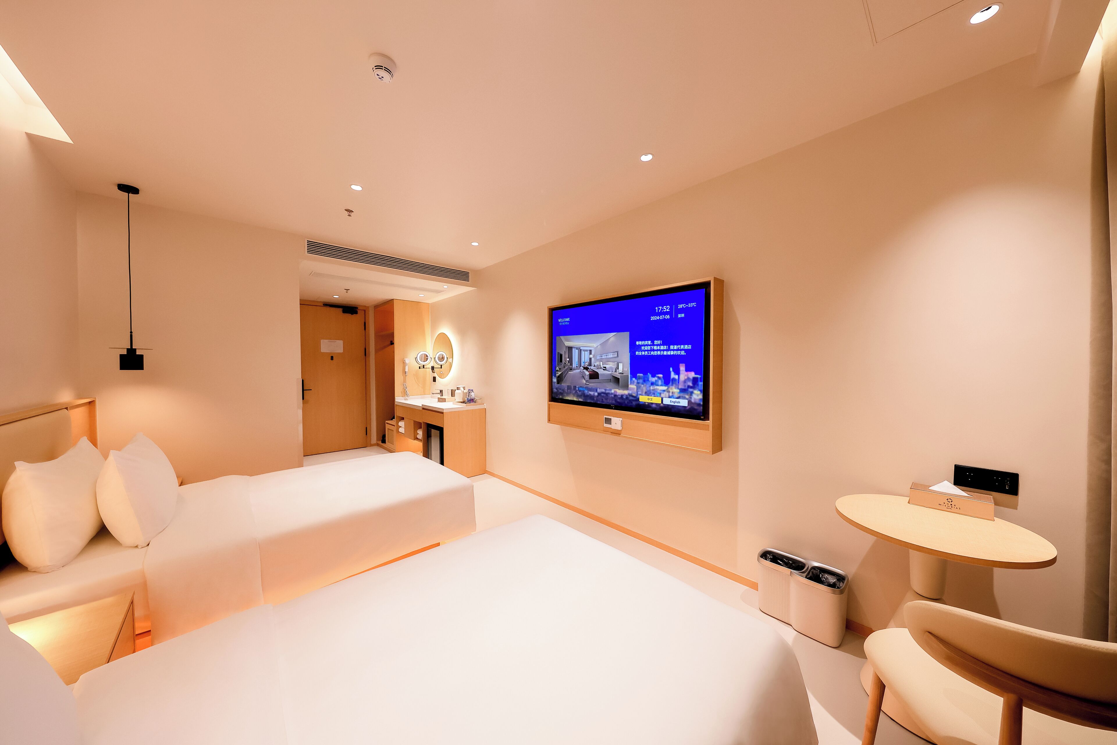 A modern hotel room with two beds, a TV, a desk, and a chair.
