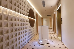 A hallway with a patterned wall, a white air purifier, and a door with a number.
