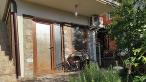 Een stenen huis met een houten deur en een metalen poort.