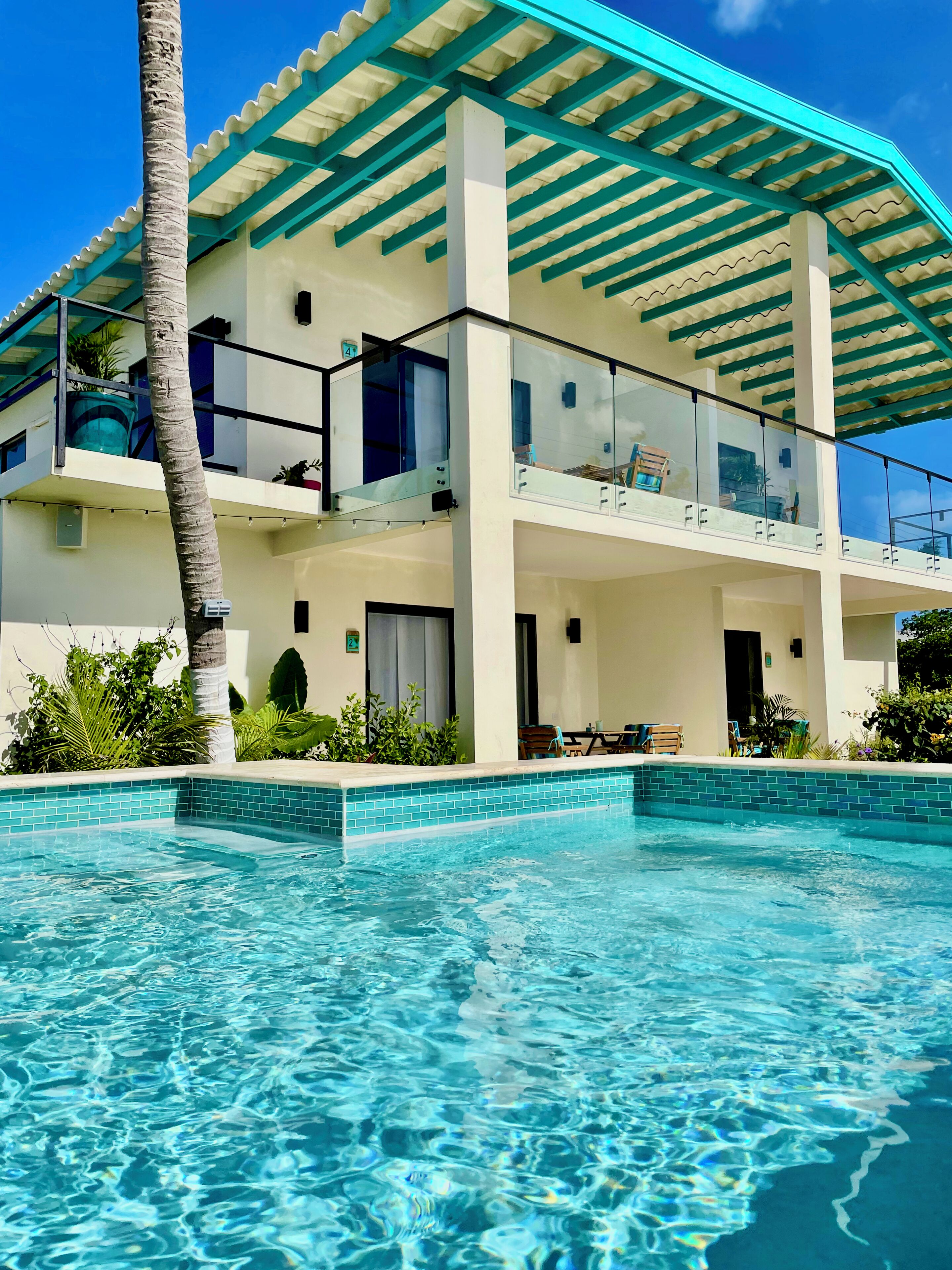 Un immeuble de deux étages avec une piscine devant.