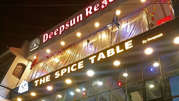 Eine Hotelansicht mit der Beschilderung 'DeepSun Regency' und dem Restaurant 'The Spice Table'.