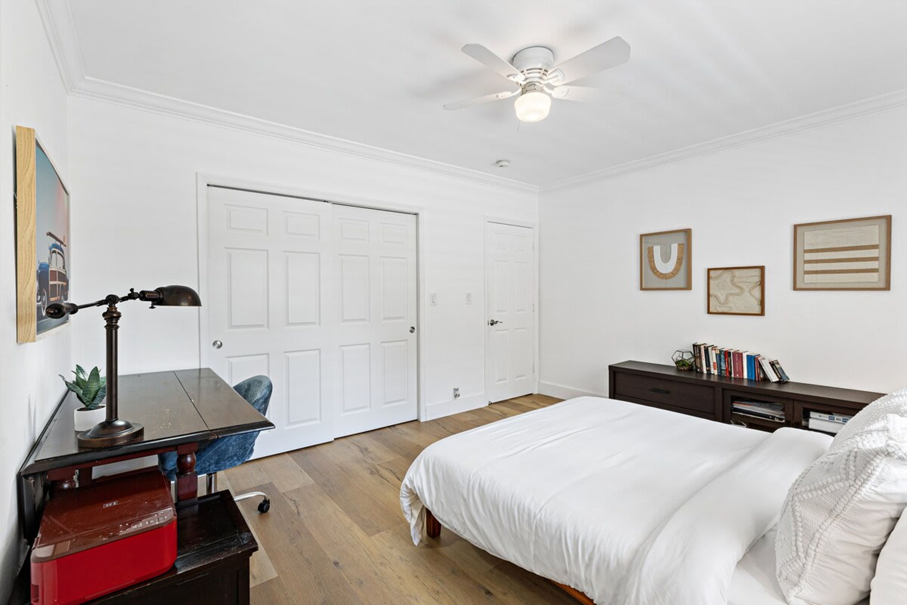 A bedroom with a bed, desk, chair, and wardrobe.