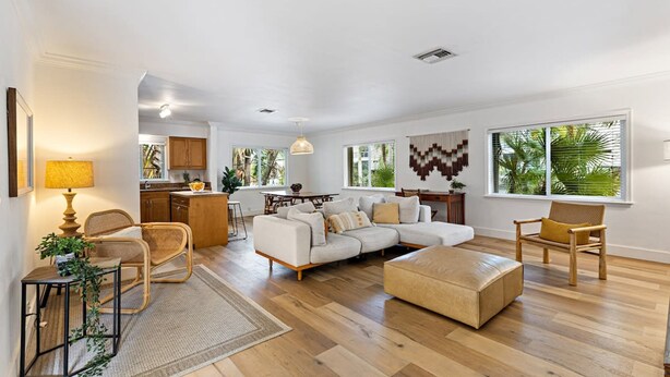 A spacious living room with a sectional sofa, a coffee table, and a dining area with a table and chairs. - Spacious Beach Apt in Las Olas Blvd (Fort Lauderdale)