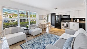 Un salon moderne comprenant un canapé, une table basse et un coin repas avec une table et des chaises.