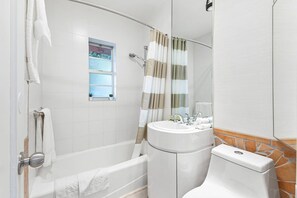 A bathroom with a bathtub, a toilet, a sink, and a shower curtain. - Delight and Cozy Apt Close to Las Olas the Beach (Fort Lauderdale)