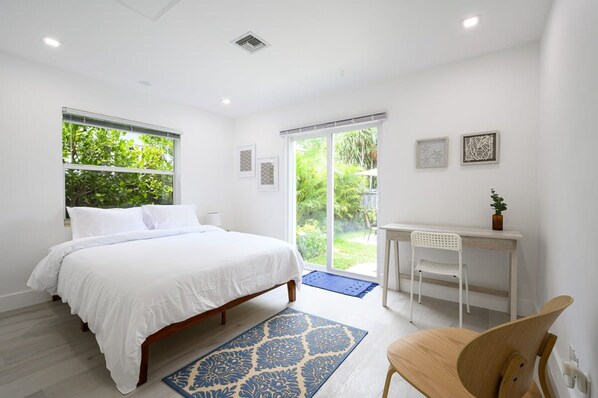 A bedroom with a bed, a desk, and a chair. - Bright Comfortable Apt in Victoria Park (Fort Lauderdale)