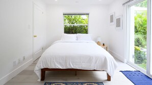 Une chambre à coucher avec un lit, une fenêtre et une vue sur la verdure.
