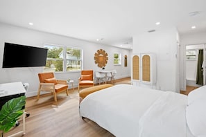 Relax in a spacious room with a large bed, flat-screen TV, and seating area.