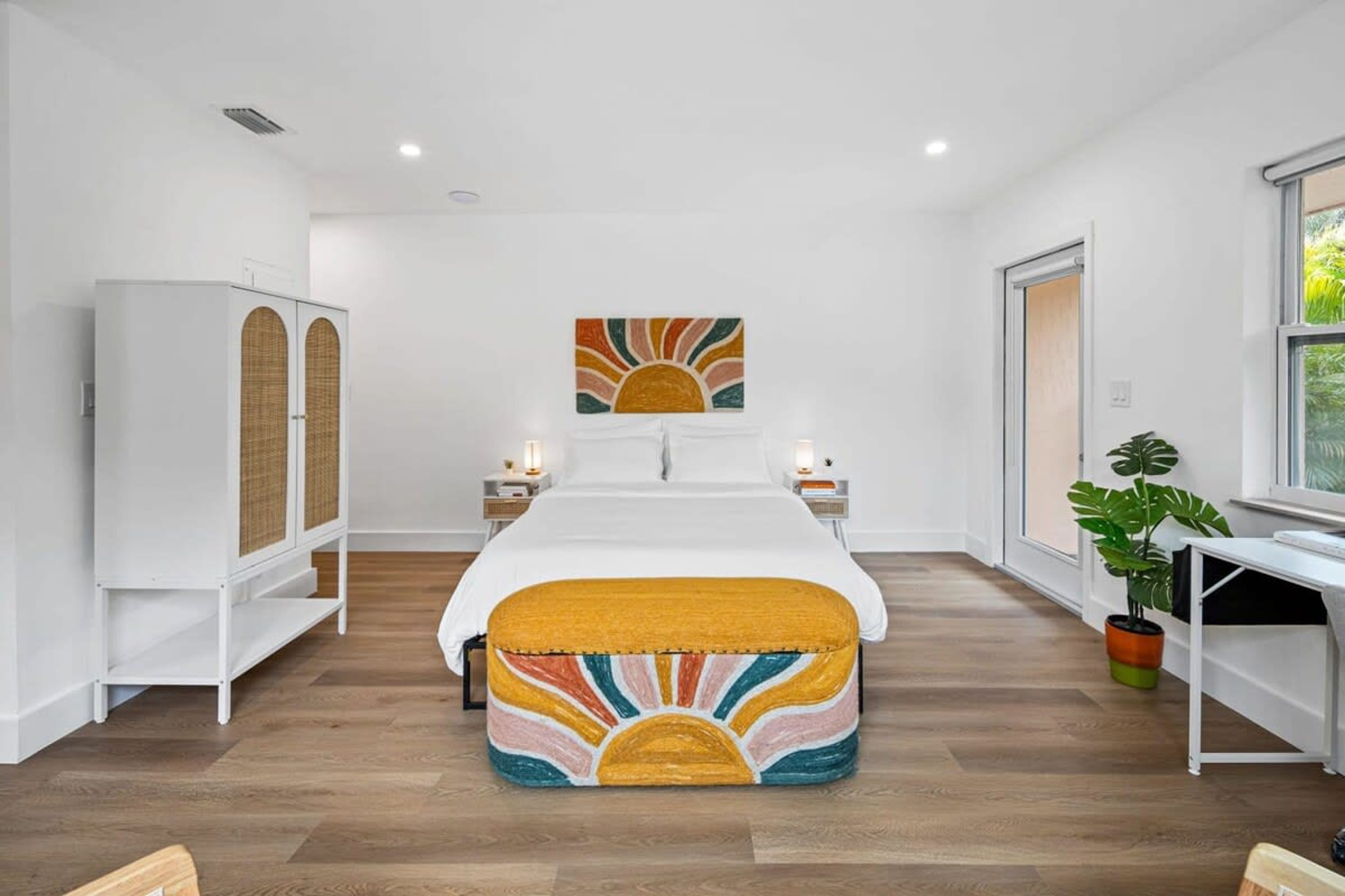Une chambre à coucher moderne, comprenant un lit, des tables de chevet, une armoire, un bureau et une fenêtre.