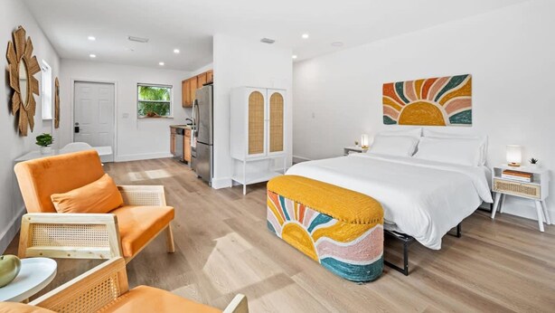 A hotel room with a bed, a sofa, a dining table, and a kitchen area. - Morning Sunshine Sailboat Bend (Fort Lauderdale)