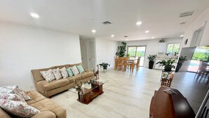Una sala de estar amplia con sofá, una mesa de centro y un comedor con sillas y una mesa.