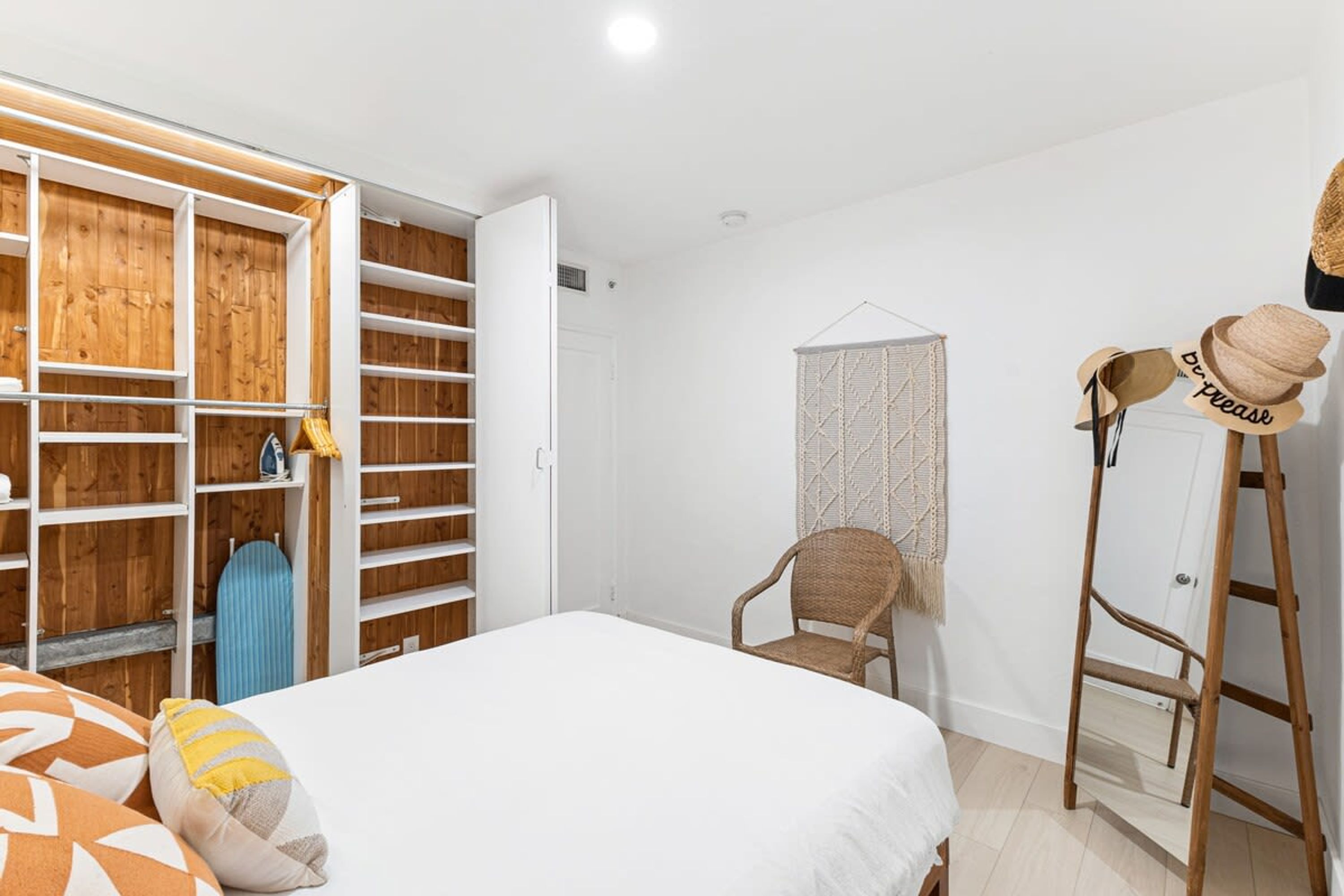 Un dormitorio con cama, armario, silla y escalera.