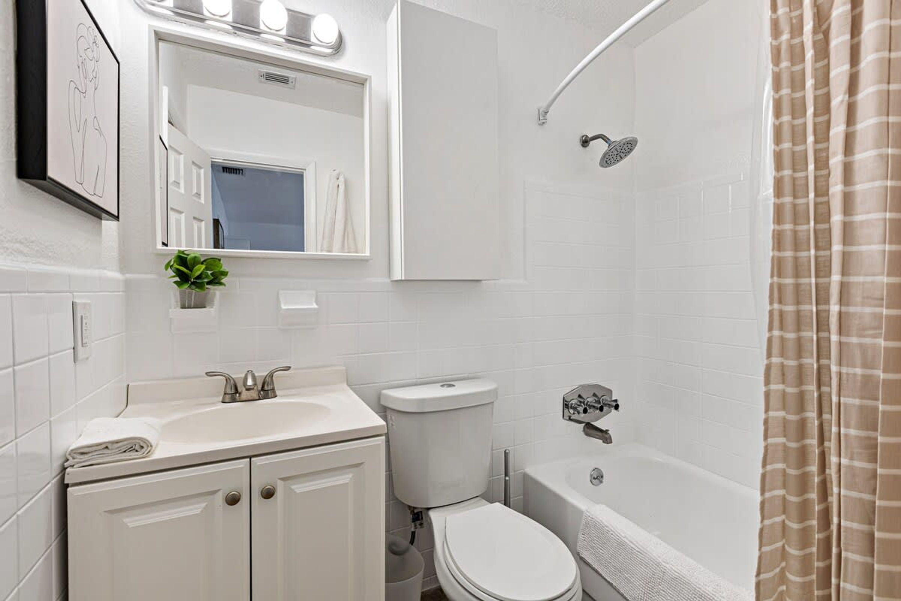 Une salle de bain moderne avec un lavabo, des toilettes et une baignoire, le tout de couleur blanche.