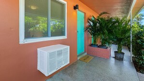 A house exterior with a window, air conditioning unit, a door, and potted plants. - Lake Ridge Villa - Free Parking (Fort Lauderdale)