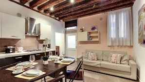 A modern kitchen with a dining area, a sofa, and a window with curtains. - I Quattro Mori by Wonderful Italy (Venice)
