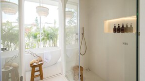A modern bathroom with a glass-enclosed shower, a wooden stool, and a shelf with toiletries. - New 1BR Private Pool Villa in Bingin, Uluwatu (Bali)