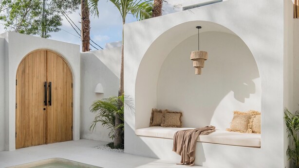 A modern outdoor pool area with a wooden door, a built-in bench with cushions, and a hanging light fixture. - New 1BR Private Pool Villa in Bingin, Uluwatu (Bali)