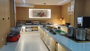 Une cuisine moderne dotée d’un long comptoir, de divers appareils de cuisson et d’une grande œuvre d’art encadrée accrochée au mur.