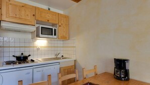 Eine Küche mit Holzausstattung, einer Mikrowelle, einem Herd, einem Geschirrspüler und einer Kaffeemaschine.