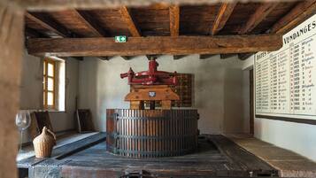 A room with a wooden ceiling, a vintage mechanical device, a wall-mounted calendar, and a window with natural light.