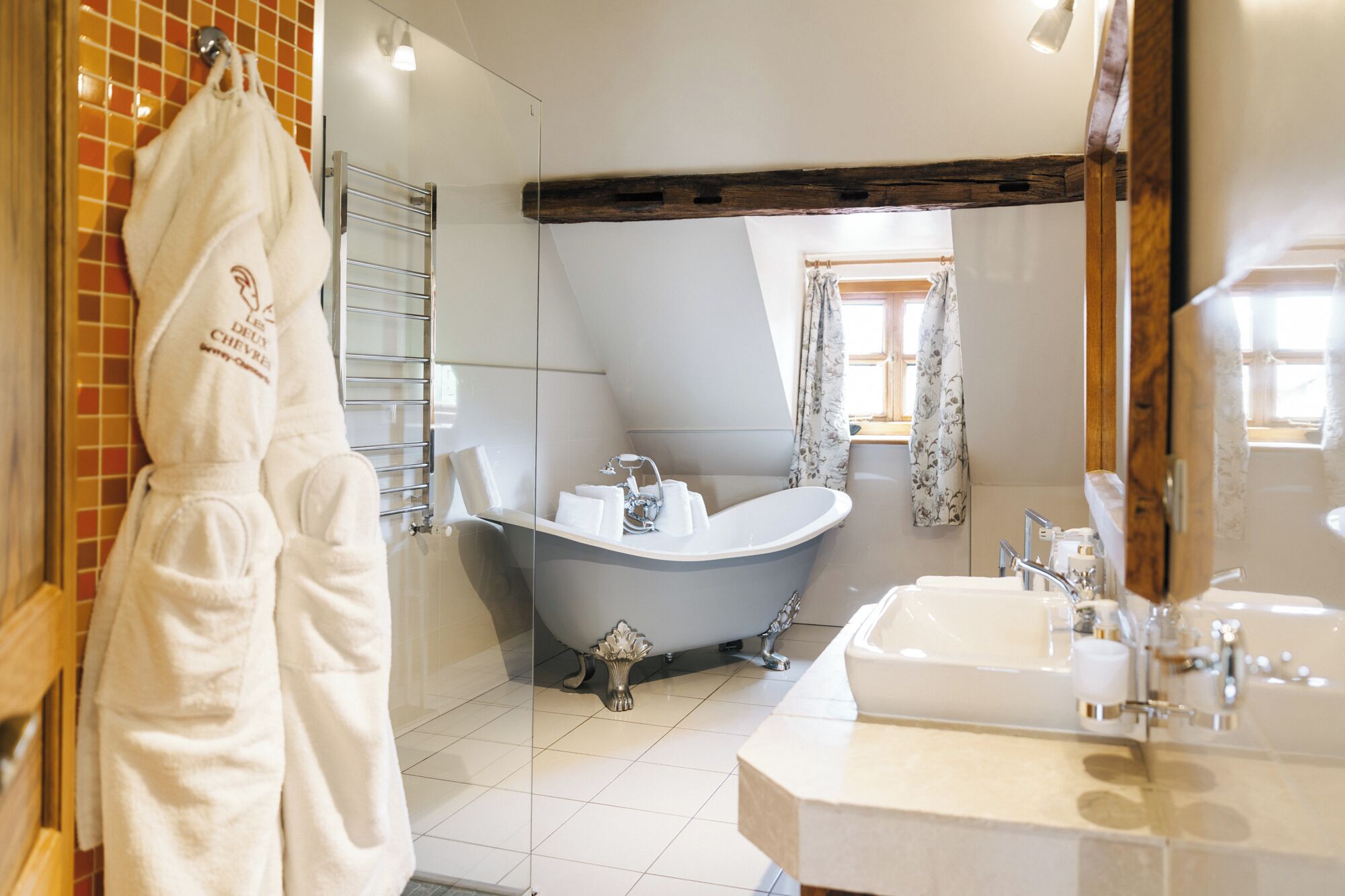 Un baño con bañera, lavabo y espejo.