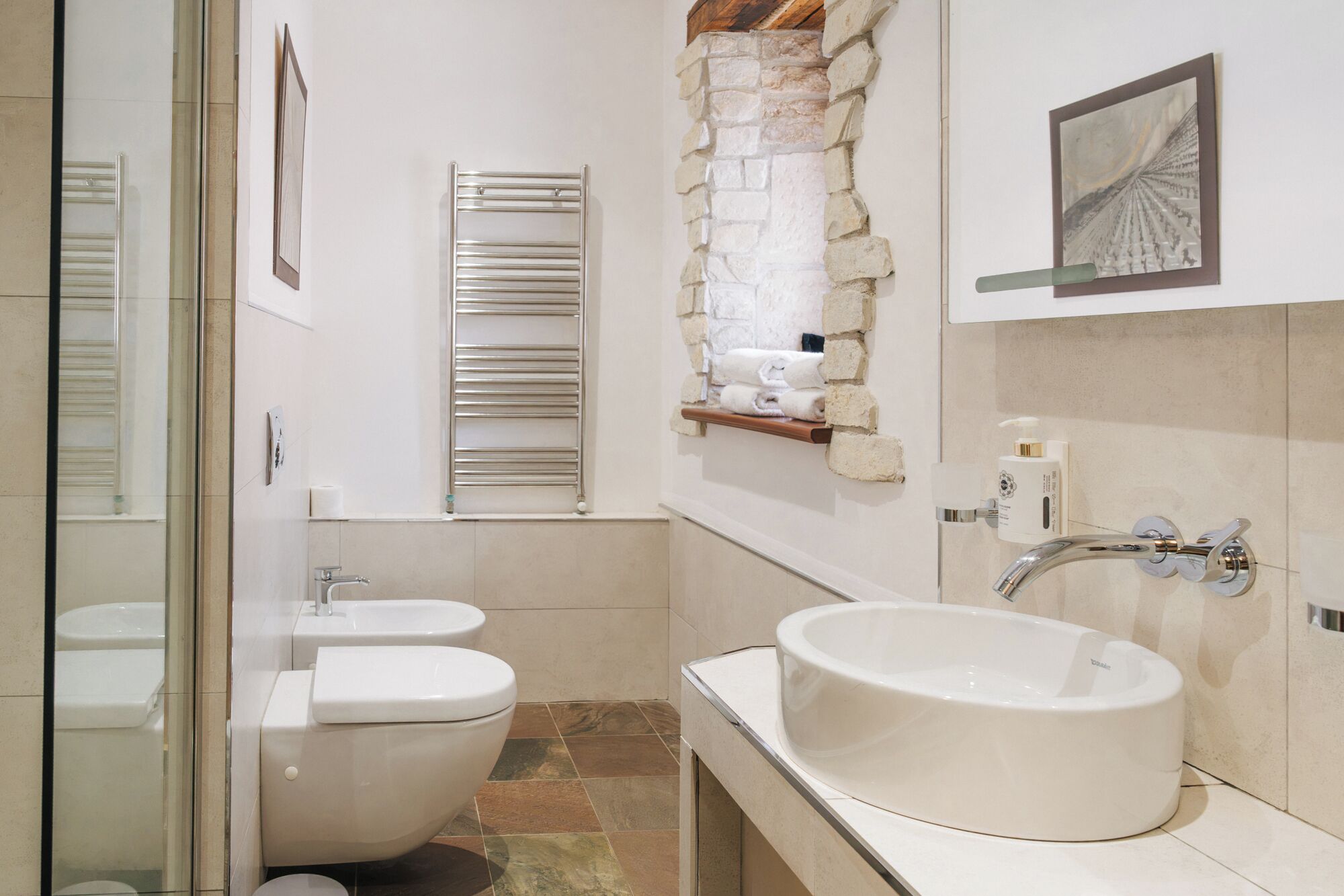 A bathroom with a toilet, bidet, and a large sink.