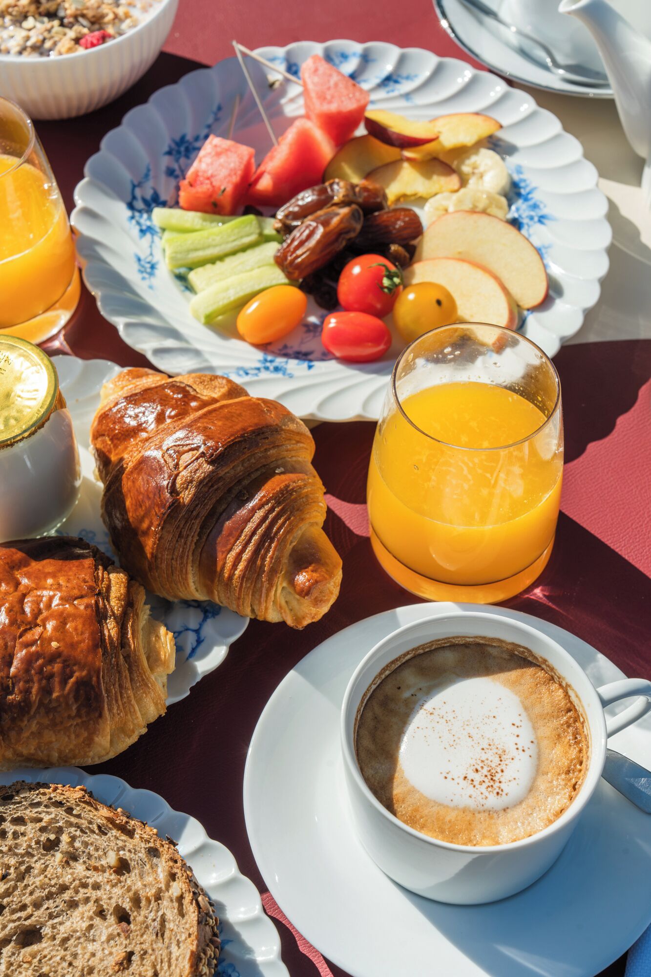 A breakfast setting with croissants, fruit, and a cup of coffee.