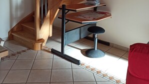 A wooden staircase with a desk and chair at the bottom. - Quiet country house  (Le Buisson)