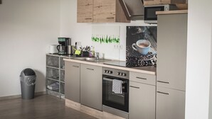 A modern kitchen with stainless steel appliances, wooden cabinets, and a coffee machine. - Vacation apartment I Waldstraße - ideal for up to 4 people (Alsbach-Hähnlein)