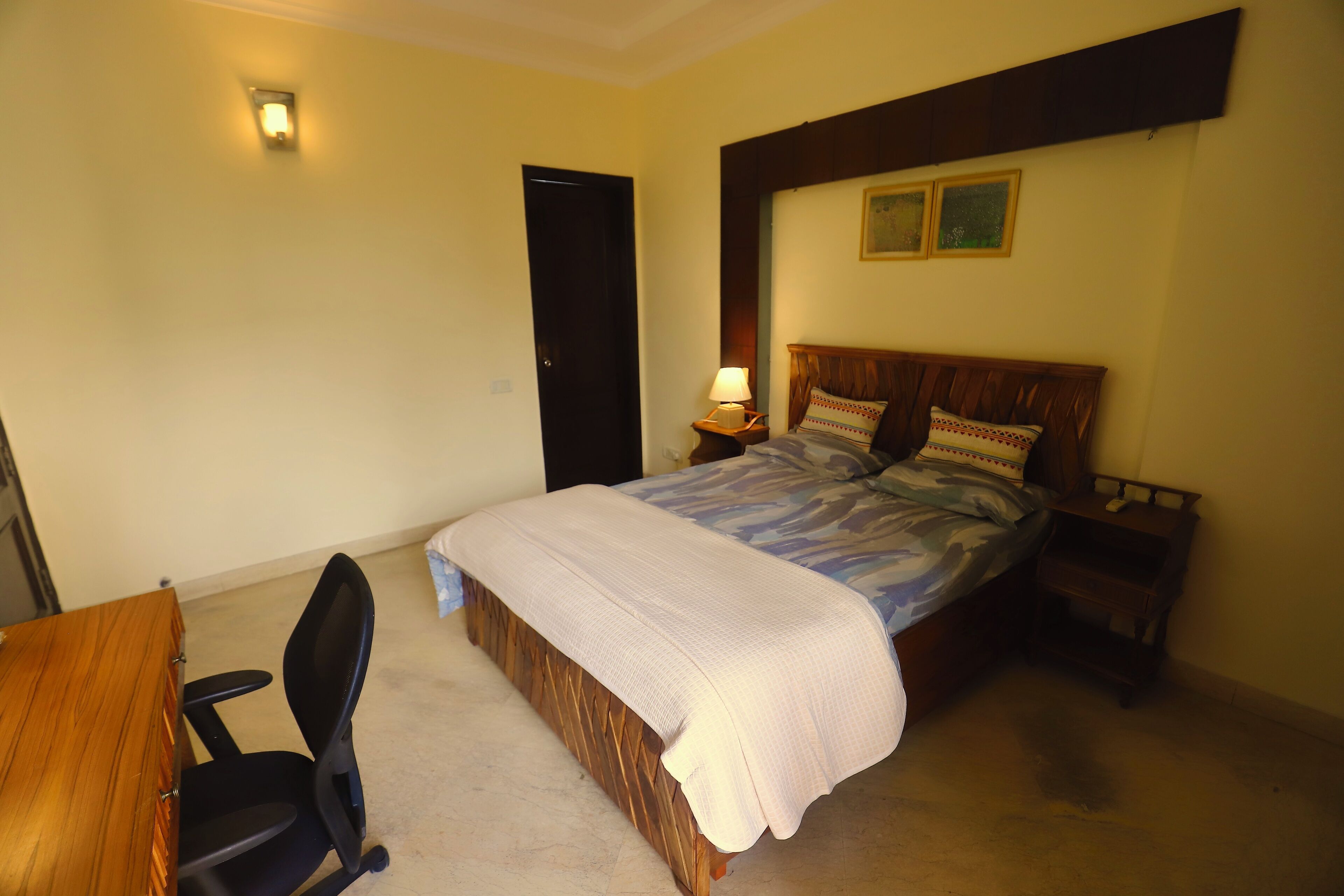 A bedroom with a bed, a desk, and a chair.