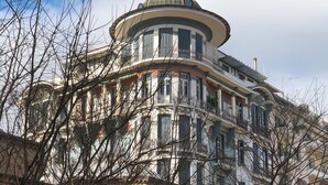 Um edifício histórico com uma cúpula arredondada e várias varandas.