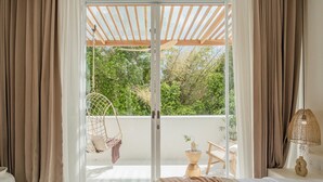 Een slaapkamer met een grote schuifpui die uitkomt op een balkon.