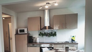 A modern kitchen with a dining area, featuring a microwave, coffee maker, and a stove. - Vacation apartment II Waldstraße - ideal for up to 4 people (Alsbach-Hähnlein)